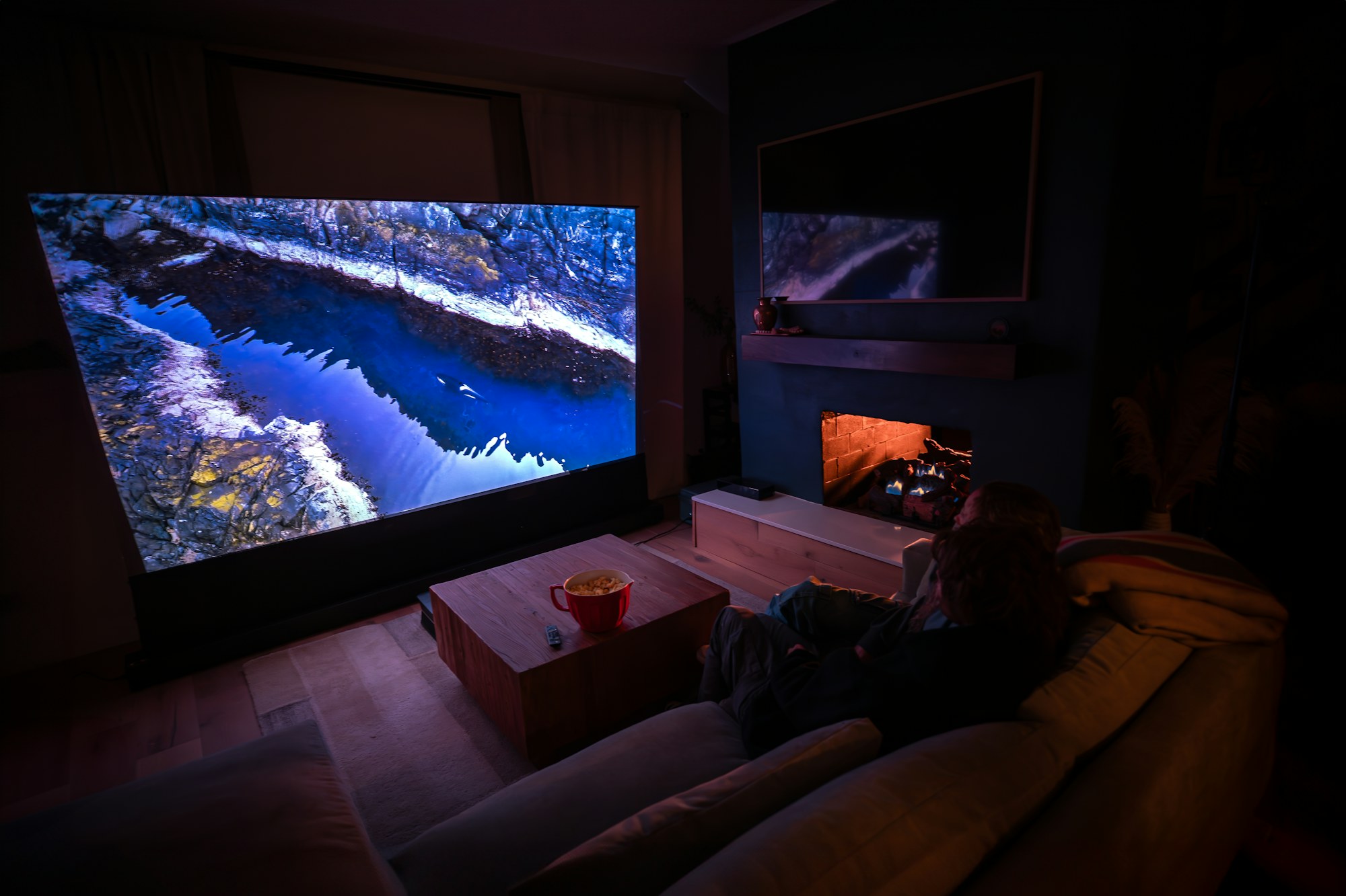 Home theatre with a projector image filling the entire wall and a couch in front