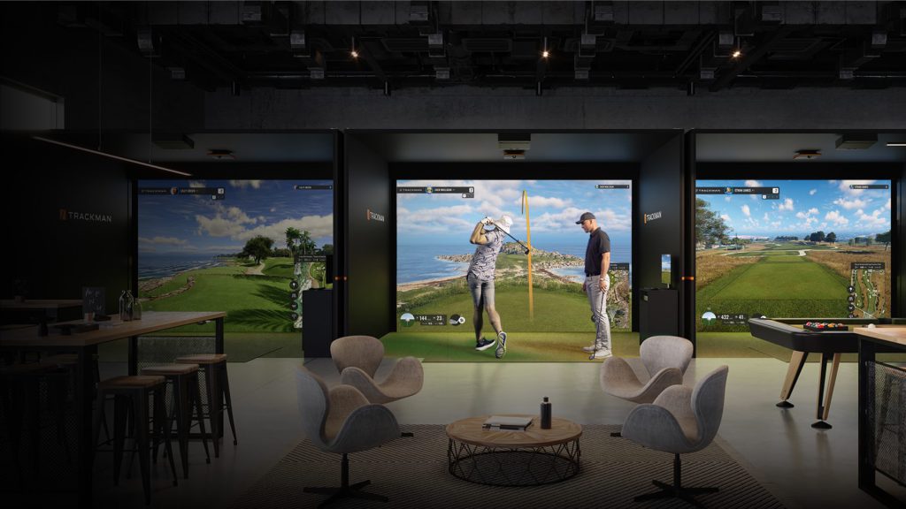 Golf simulator bays with comfortable lounge seating positioned behind the hitting area